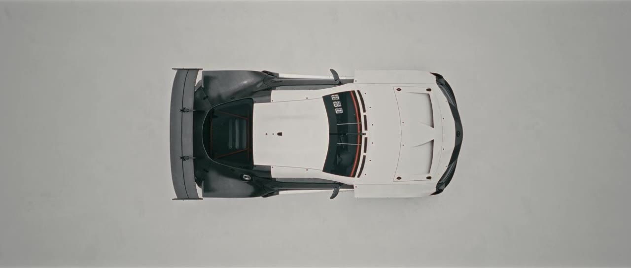 A plan view of a car on a seamless grey ground — the orthographic read.